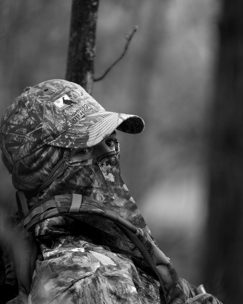 Black and white portrait of a hunter in camo and a face mask