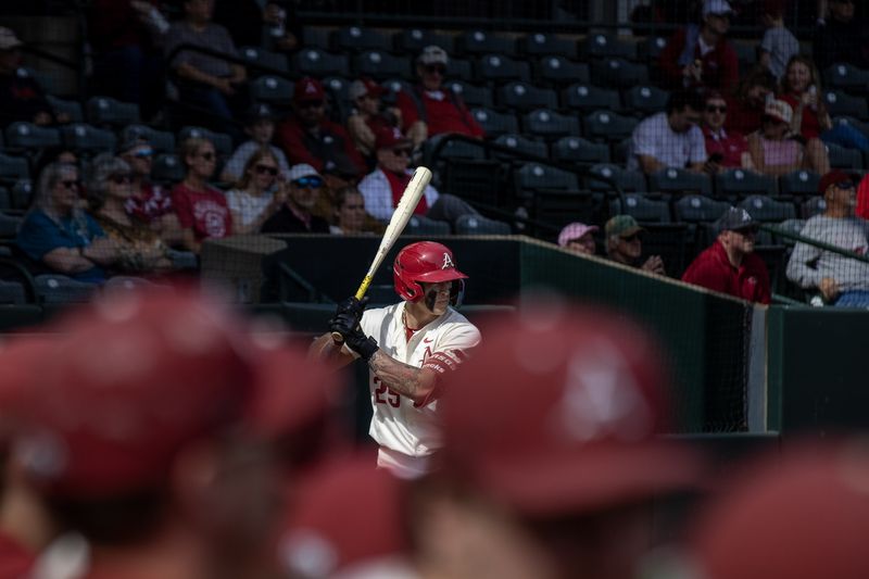 A batter sets up at the plate, framed by blurred red caps in the dugout