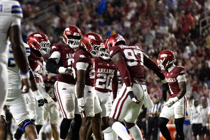 Arkansas defenders celebrate together during a night game